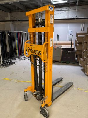 un chariot élévateur au milieu d'un entrepôt rempli de cartons