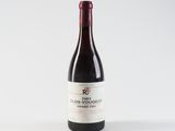 a bottle of red wine sitting on top of a white table