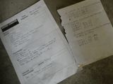 a piece of paper on the floor next to a piece of paper with writing on it