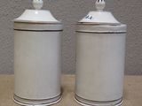 two white canisters sitting on a table next to each other