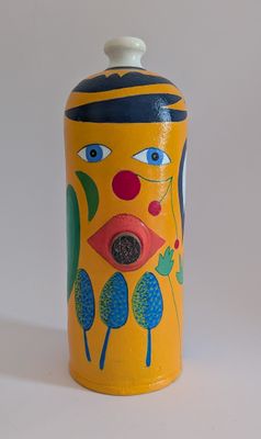 vase jaune sur lequel est peint un visage sur le côté