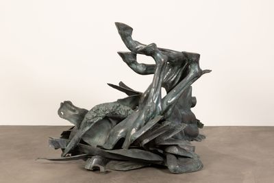 une sculpture représentant un oiseau perché sur un tas de feuilles
