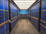 a long hallway with blue walls and wooden benches