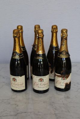 four bottles of champagne are lined up on a marble table