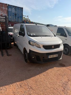 two vans parked next to each other in the dirt