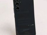 the back of a black samsung phone sitting on top of a white table
