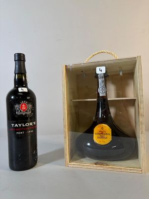 une bouteille de vin dans un coffret en bois à côté d'une bouteille de vin