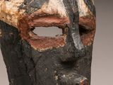 an image of a wooden mask with a black face and a brown nose