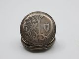 an antique silver pocket watch on a white surface