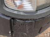 a close up of a car ' s headlight on a dirt road