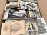 une boîte en carton remplie de vieilles photos de personnes