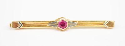 a close up of a gold ring with a ruby stone