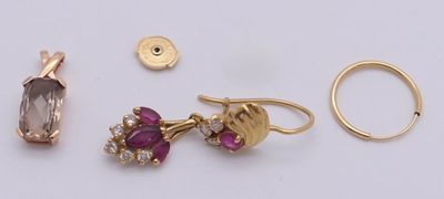 deux paires de boucles d'oreilles, une bague et une bague posées sur une surface blanche