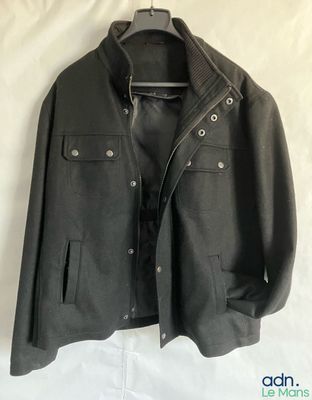 an image of a jacket hanging on a hanger on a bed