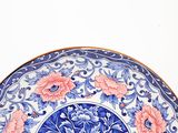 a blue and white plate with pink flowers on it