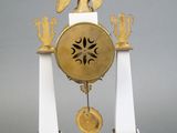 a white and gold clock with an eagle on top