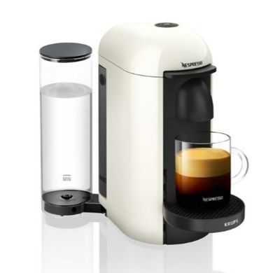 une machine à café blanche avec une tasse de café à côté
