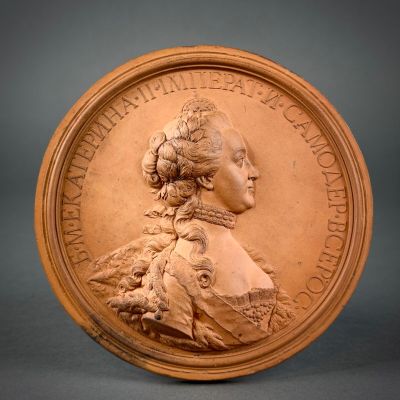 an image of a bronze medallion with a woman ' s profile