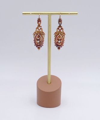 a close up of a pair of earrings on a stand
