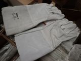 pair of white leather work gloves sitting on top of a cardboard box
