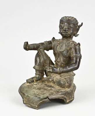 une photo d'une statue en bronze représentant un homme assis sur un rocher