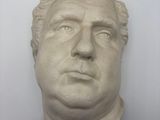 plaster bust of a man ' s head on a white wall