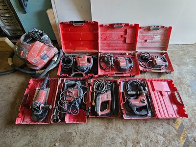un assortiment d'outils dans une boîte à outils rouge posée par terre