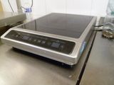 a silver stove top with a black burner on it