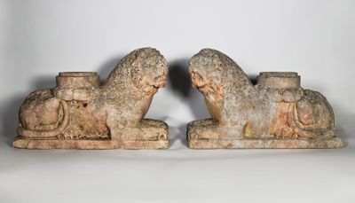 une paire de sculptures en pierre représentant un lion et un cheval, posées sur un socle blanc