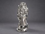 a close up of a metal sculpture of a lion on a gray background