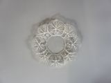 une assiette blanche sur laquelle est posé un napperon blanc