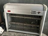 un climatiseur posé sur une grille métallique, près d'un mur