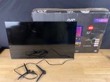 La télévision est posée sur la table, à côté du carton.
