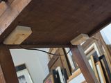 a wooden table with some pictures on the wall behind it