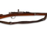 un vieux fusil avec un canon en bois et une bretelle en cuir