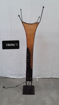 un grand vase en verre posé sur un socle en métal