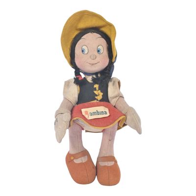 peluche représentant une petite fille assise sur une chaise, avec une étiquette portant son nom