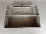an old metal box with a lid on a table
