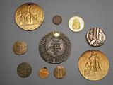 plusieurs pièces de monnaie et une médaille posées sur une table, sur fond gris