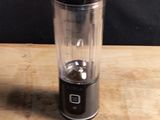 a blender sitting on a wooden table with a black background