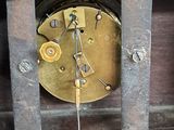 a close up of a clock with a pendulum on it