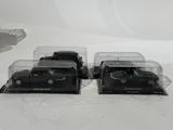 two black toy trucks that are sitting on a white surface