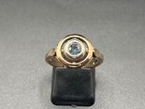 Gros plan sur une bague en or ornée d'une topaze bleue