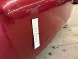 a close up of a red car with a sticker on it