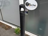 a parking meter in front of a building with a sign on it