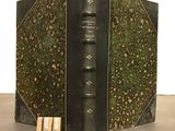 an old book with a bookmark on it sitting on a table
