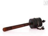 a small metal object with a wooden handle on a white surface