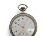 une montre de poche en argent posée sur une surface blanche, sur fond blanc