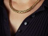 a woman wearing a black shirt and a gold chain necklace