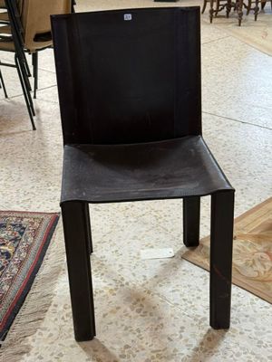 une chaise noire placée au milieu d'un salon